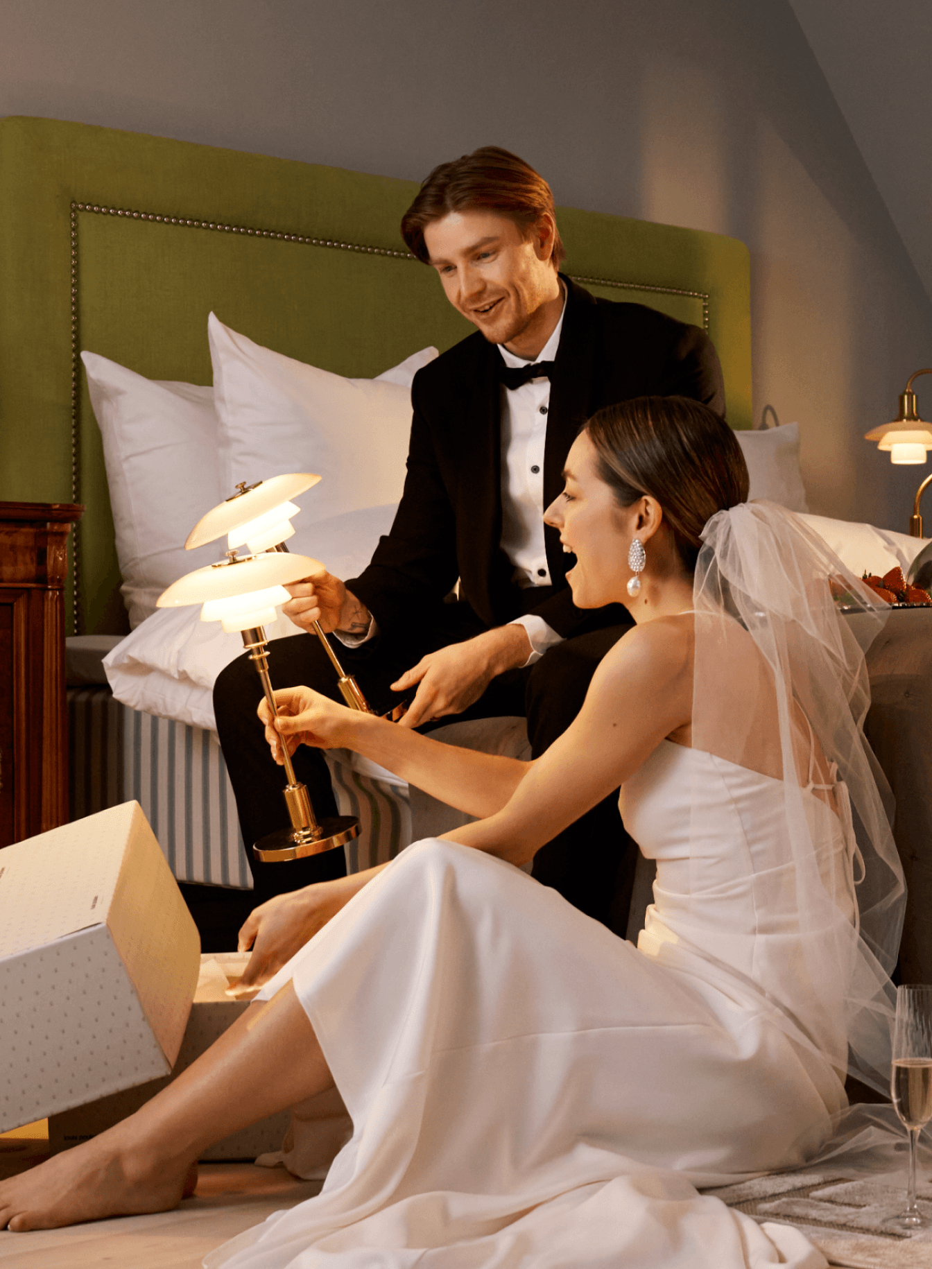 PH 2/1 Portable bordlampe i messing finish i soveværelse med par og gaver, © 2025 Louis Poulsen.