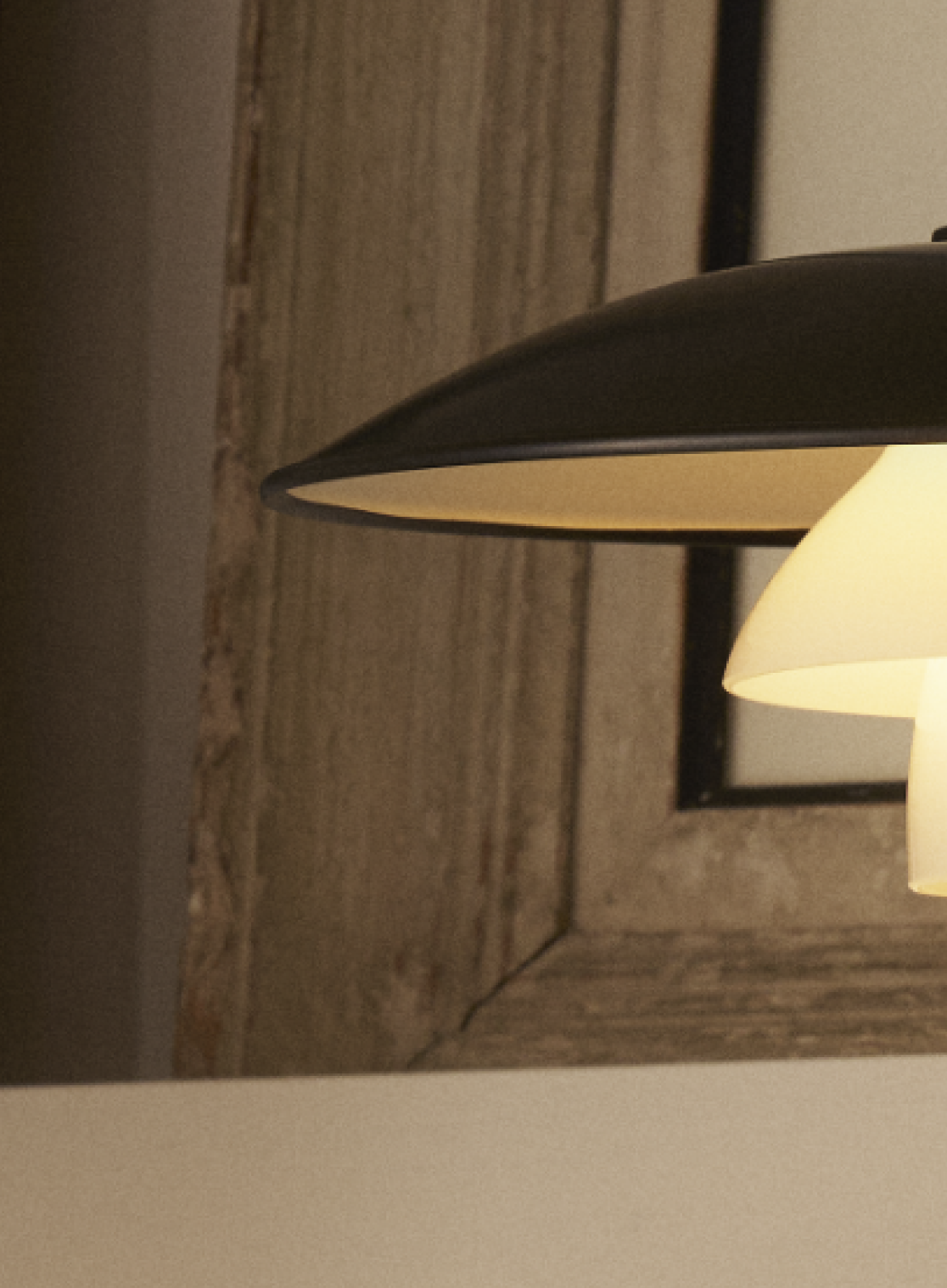 PH 3/2 Aged Brass table lamp with a sleek metal finish, set against a neutral-toned background, © 2025 Louis Poulsen.