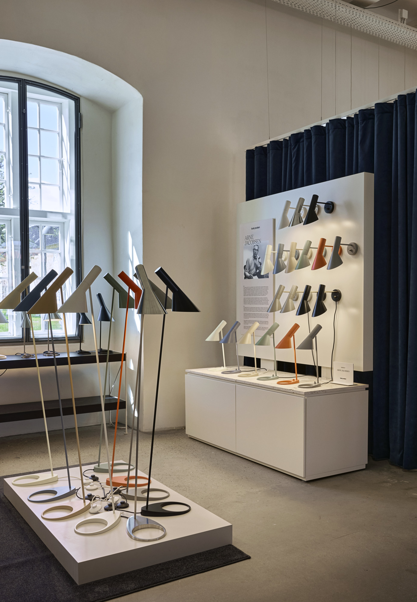 AJ bord-, gulv- og væglamper i flere farver udstillet i Louis Poulsens showroom i København, © 2025 Louis Poulsen.