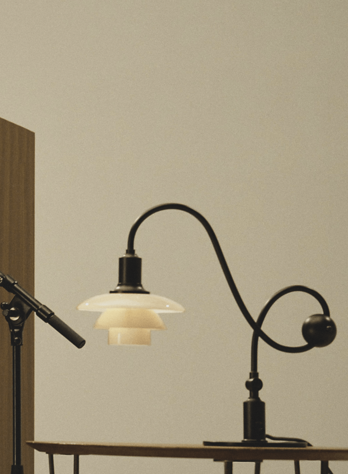 Illuminated PH 1/1 Piano Lamp beside recording equipment, © 2025 Louis Poulsen.