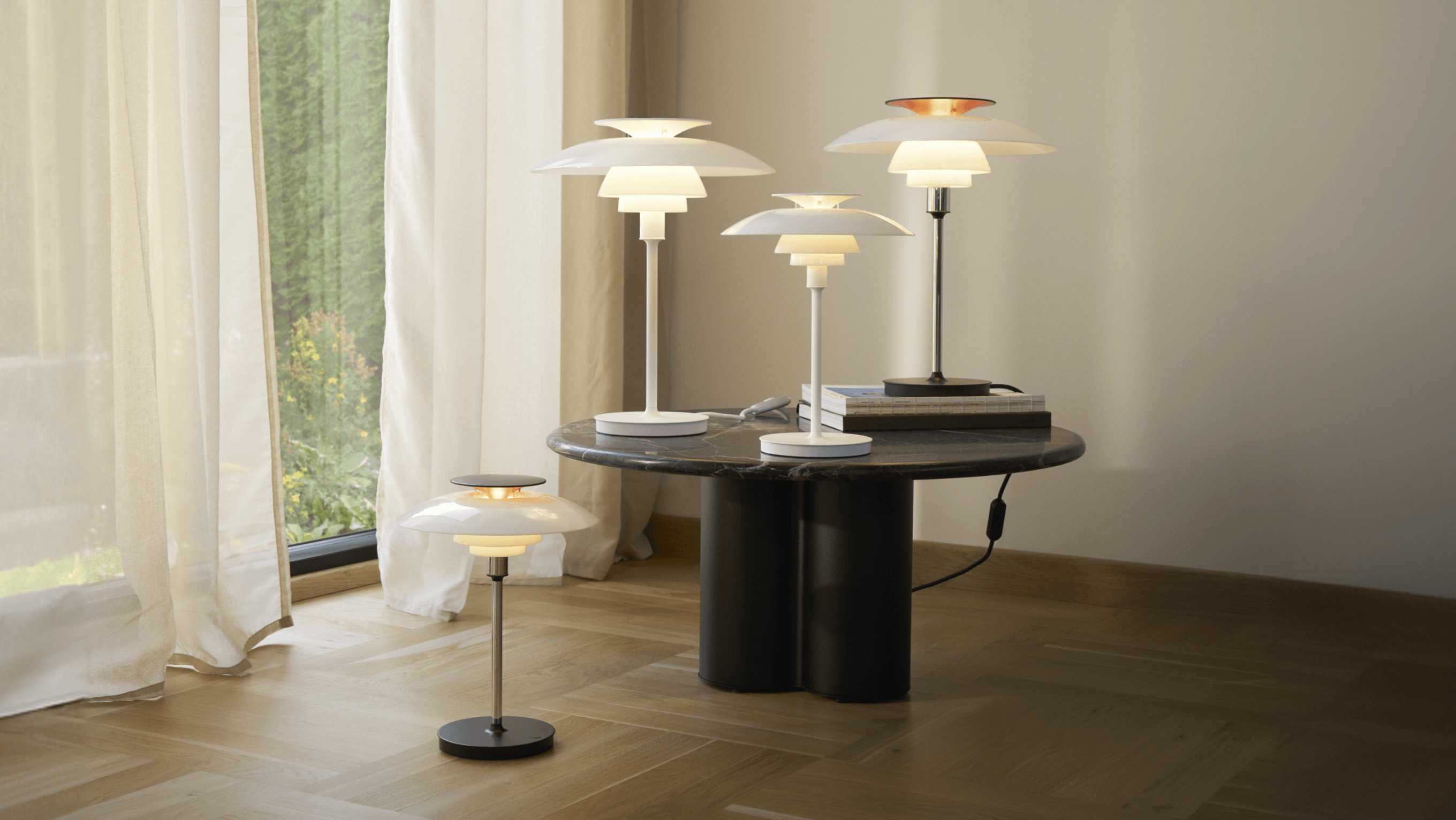 PH8 80 table lamps on a marble table with books and soft lighting, © 2025 Louis Poulsen.