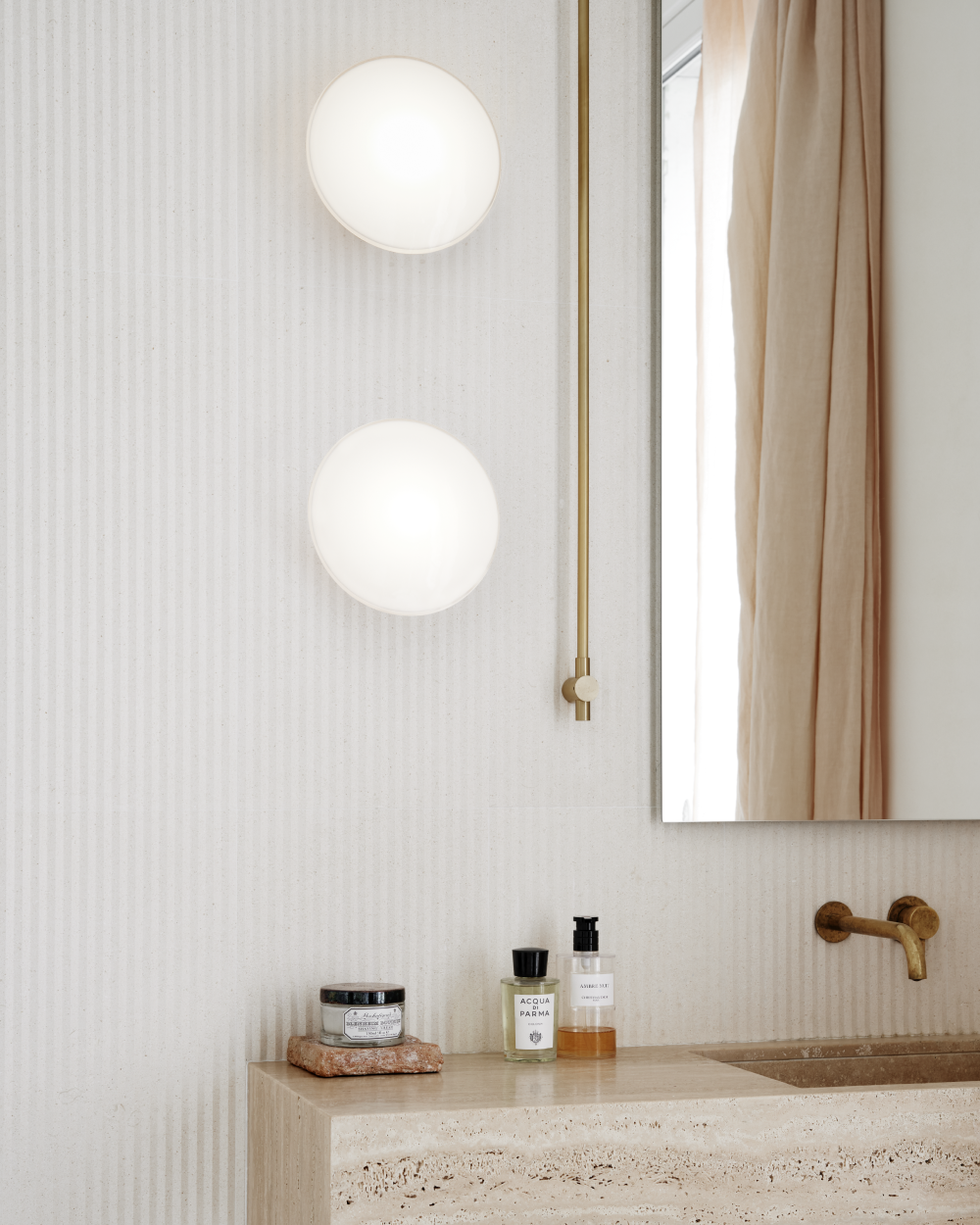 AJ Eklipta vägglampor ovanför badrumstvätt i mjukt dagsljus, © 2025 Louis Poulsen.