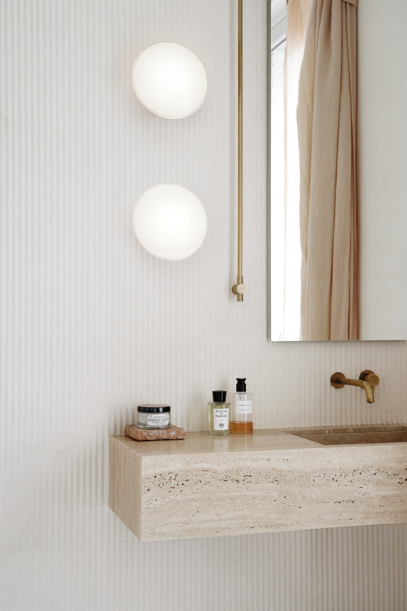 AJ Eklipta wall lamps above bathroom sink in soft daylight, © 2025 Louis Poulsen.