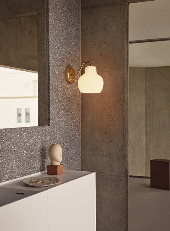 VL Ring Crown Wall 1 黄铜壁灯安装于浴室混凝土墙上镜旁, © 2025 Louis Poulsen.