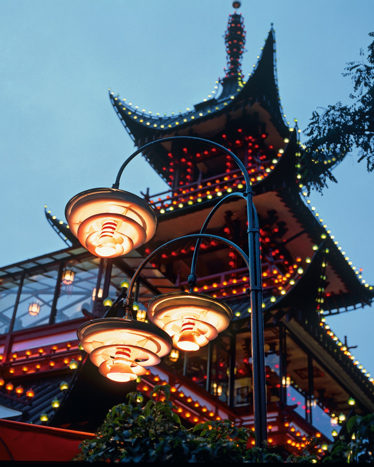 PH outdoor lamps illuminating Tivoli Gardens pagoda at dusk, © 2025 Louis Poulsen.