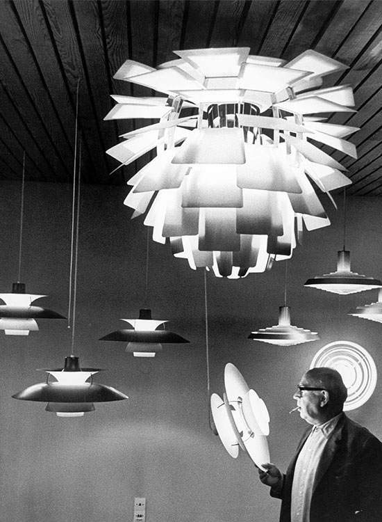 Poul Henningsen observing Artichoke and PH lamps hanging in showroom, © 2025 Louis Poulsen.