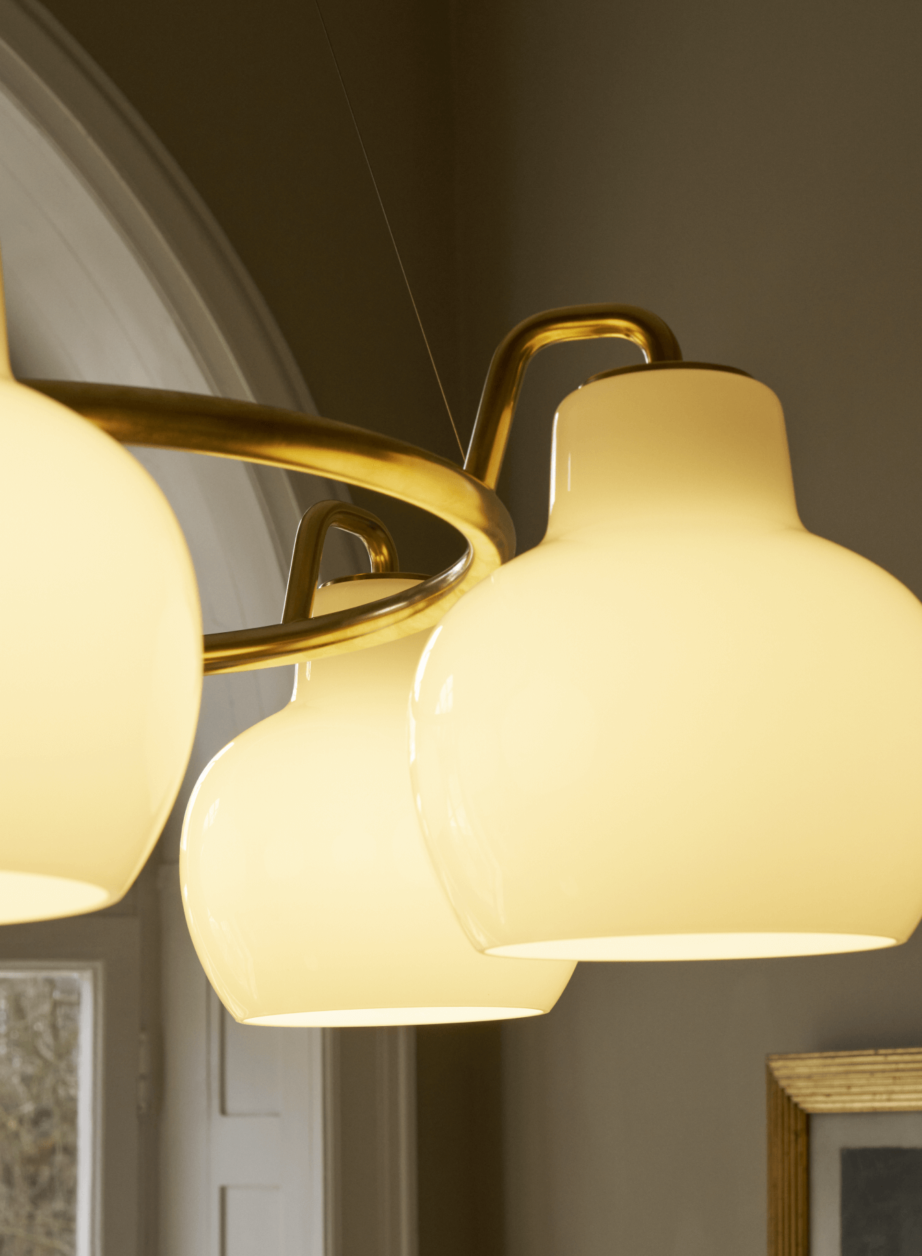 VL Ring Crown pendel med messing og opalglas lyser i interiør, © 2025 Louis Poulsen.