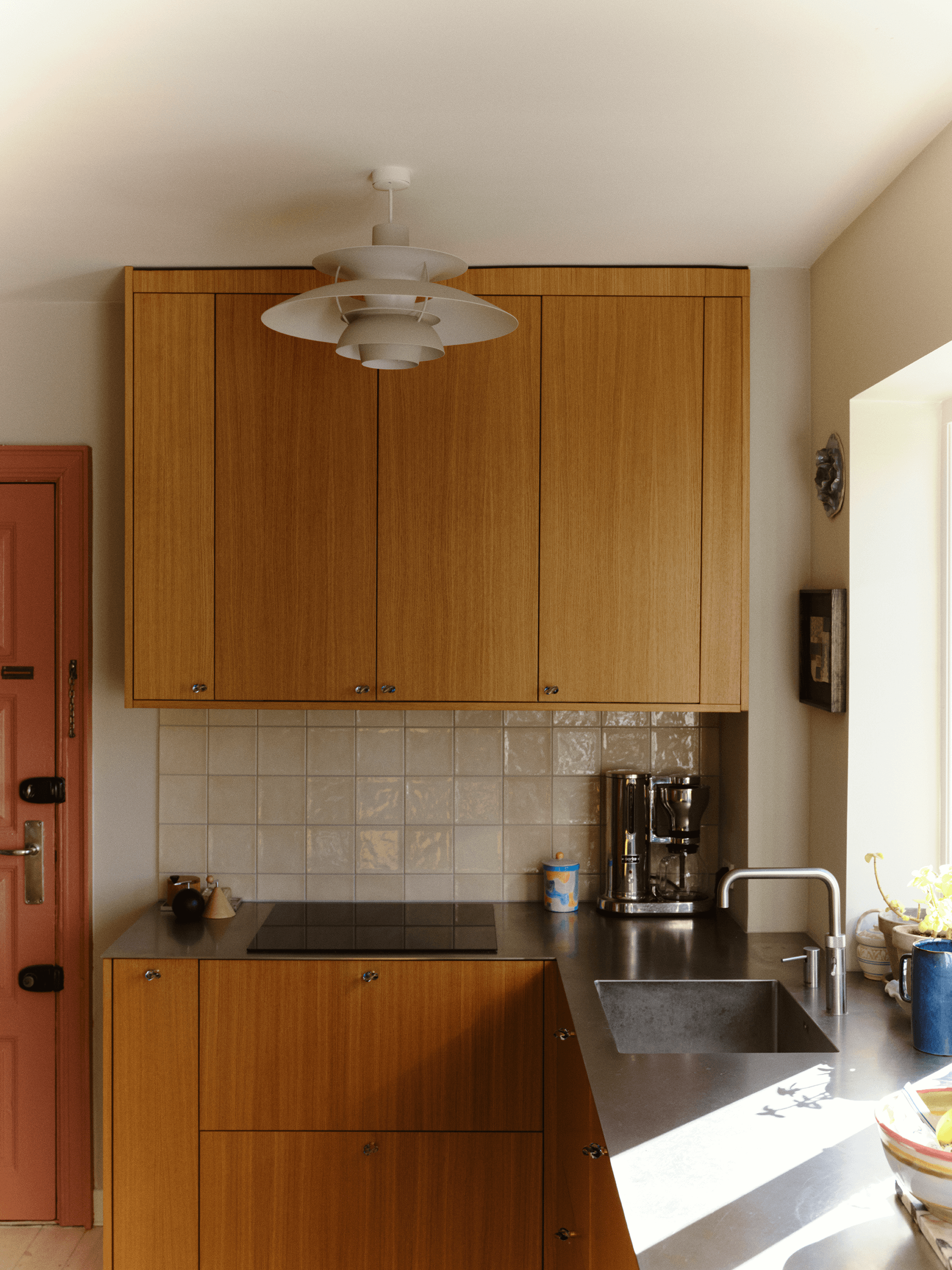 PH 5 pendant centred above compact kitchen with oak cabinetry and daylight, © 2025 Louis Poulsen.
