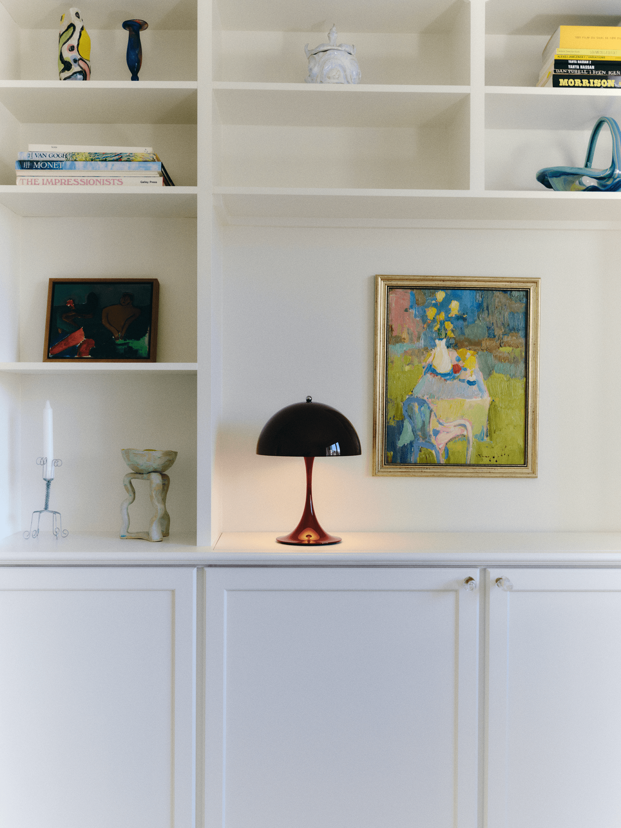 Panthella Table Lamp displayed on built-in shelves among art and ceramics, © 2025 Louis Poulsen.